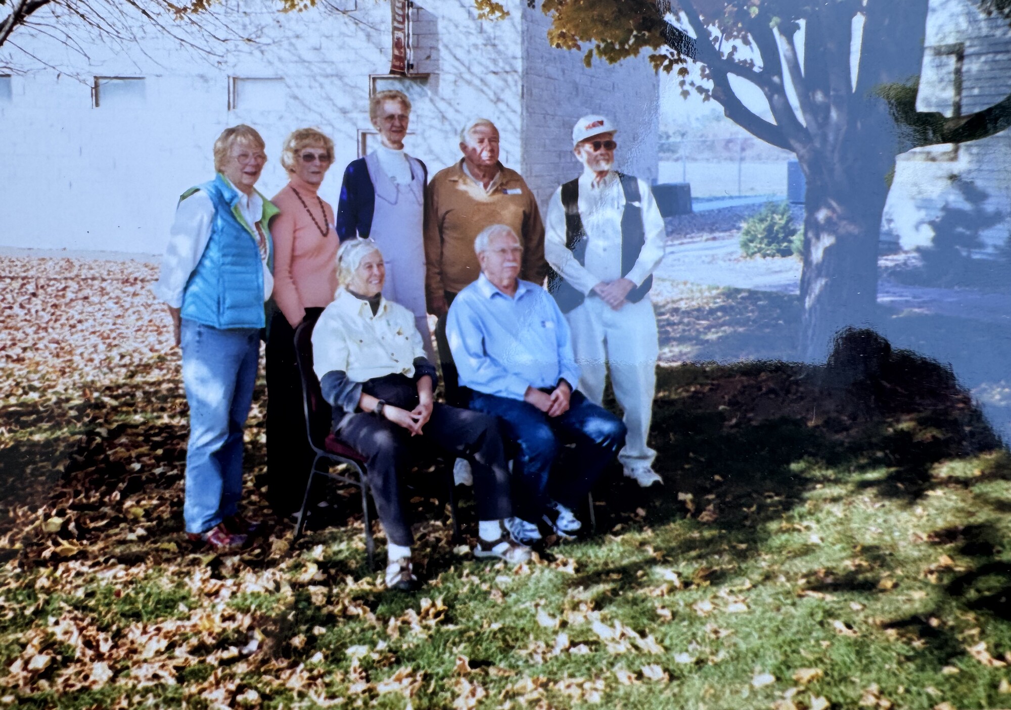 Family gathered outdoors under autumn trees