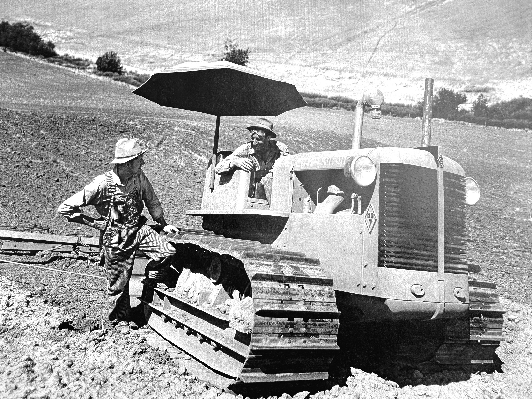 Two men with an Allis-Chalmers HD-7 crawler tractor in a summer-fallow field