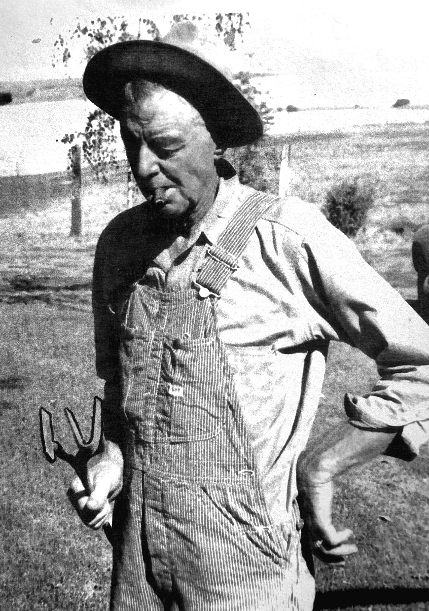 Shelley Aldrich in striped overalls and a hat, pipe in mouth